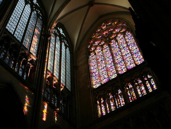 Light comes through Gerhard Richter's window in Cologne Cathedral, comprised of squares of 72 different colors; the light falls onto a wall on the left side, painting the wall in pillars of rainbow light