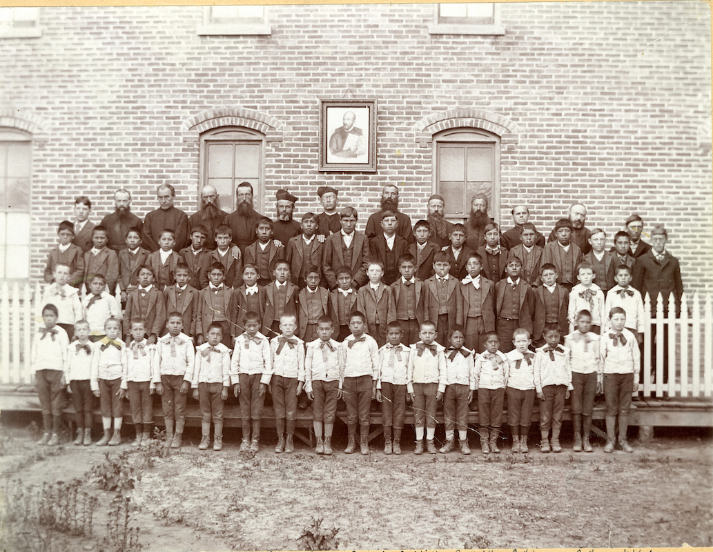 Jesuits and Lakota students pose for a photograph outside Holy Rosary Mission.