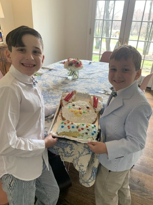 The author's two sons smile and hold a bunny-shaped cake that they made for Easter.