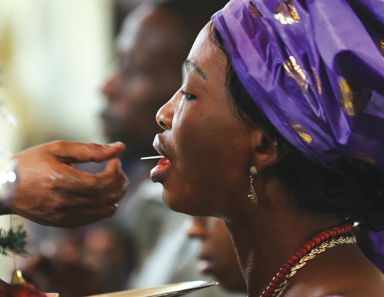 A woman receives communion during a New Year's day service at the Holy Rosary Catholic Church in Abuja, January 1, 2014. REUTERS/Afolabi Sotunde