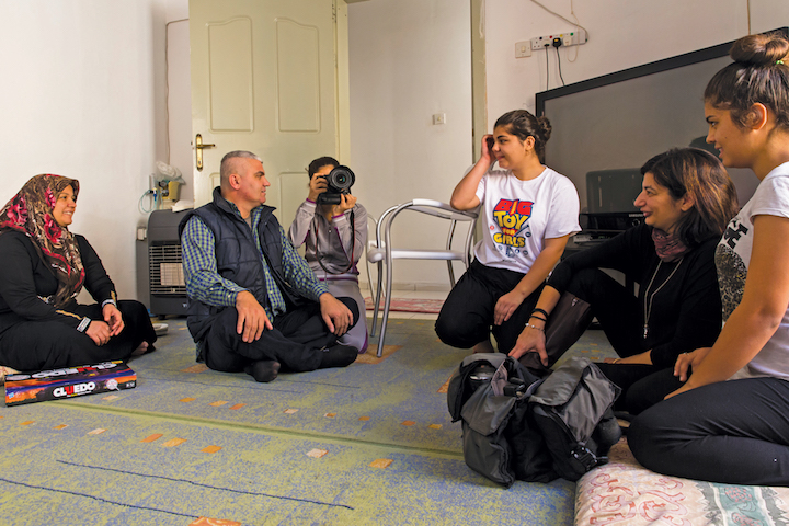 Refugees sit with Katrine Camilleri of Jesuit Refugee Service Malta