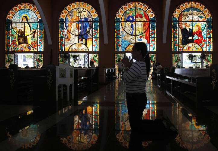 A woman prays during the Stations of the Cross on Holy Thursday at a church in Manila, Philippines, March 28. Holy Week marks a time of prayer and recalling the Passion of Jesus. (CNS photo/Cheryl Ravelo, Reuters) 