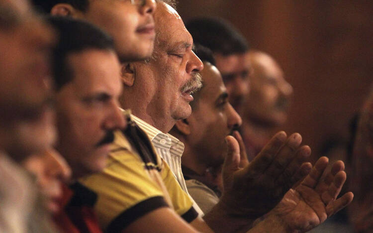 Christians pray during Coptic Orthodox Easter liturgy at main cathedral in Cairo.