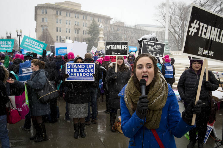Woman leads chant against contraceptive mandate in front of U.S. Supreme Court in Washington.