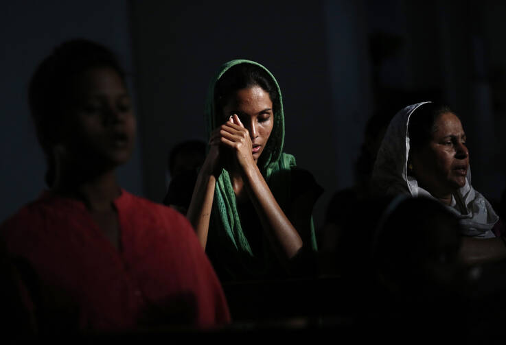 Catholic devotees pray during Good Friday liturgy in New Delhi. (CNS photo/ Anindito Mukherjee, Reuters)