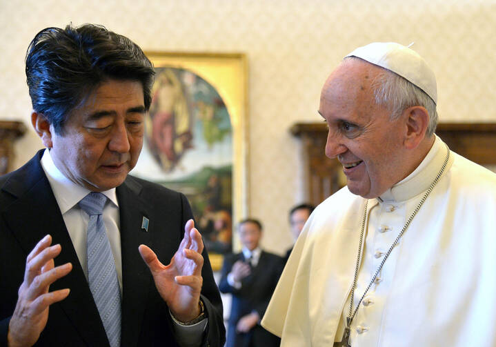 Japanese Prime Minister Shinzo Abe gestures as he speaks to Pope Francis while exchanging gifts during private audience at Vatican in June 2014.