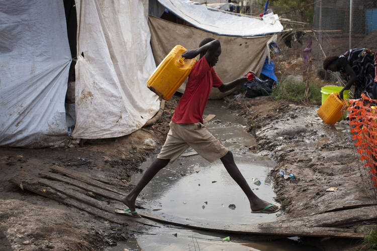 South Sudanese boy fetches water in displaced person camp.