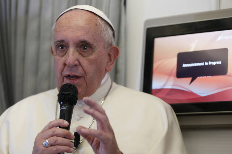 Pope Francis answers questions from the media aboard his flight to Manila, Philippines, Jan. 15. (CNS photo/Paul Haring) 