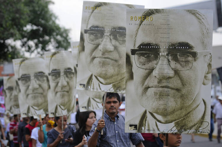 People carry portraits of Salvadoran Archbishop Oscar Romero during rally in his honor in San Salvador.