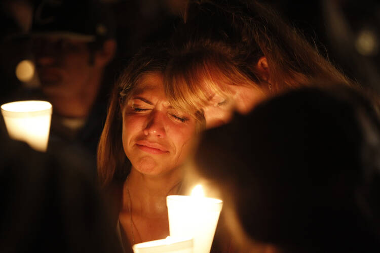 Women console one another during a candlelit vigil following a mass shooting at Umpqua Community College in Roseburg, Ore., Oct. 1. (CNS photo/Steve Dipaola, Reuters) 