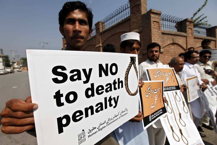 Human rights activists hold placards during a rally in early October against the death penalty in Peshawar, Pakistan. (CNS photo/Arshad Arbab, EPA)