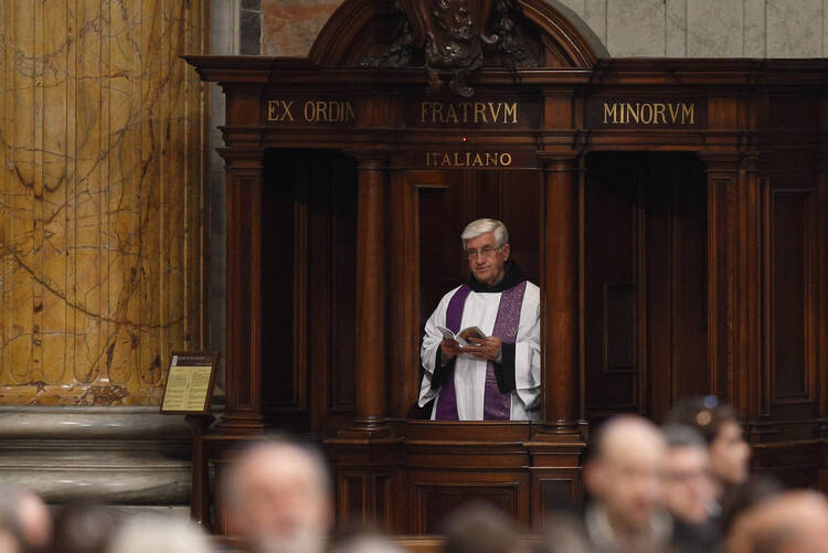 A priest participates from his confessional as Pope Francis leads a Lenten penance service in St. Peter's Basilica at the Vatican in this March 13, 2015, file photo. (CNS photo/Paul Haring) 