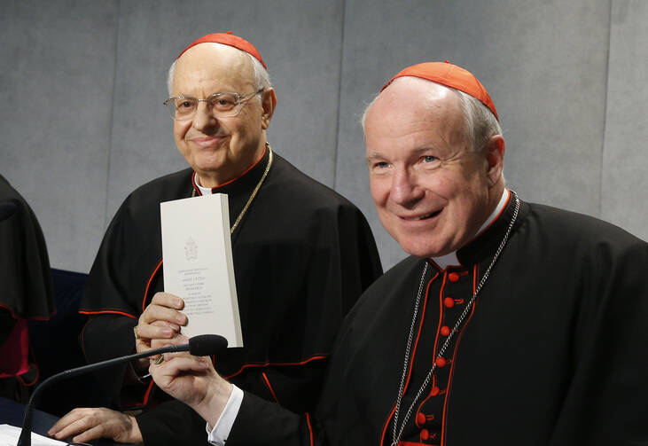 Cardinal Lorenzo Baldisseri, general secretary of the Synod of Bishops, and Austrian Cardinal Christoph Schonborn, holds a copy of Pope Francis' apostolic exhortation on the family, "Amoris Laetitia" ("The Joy of Love"), during a news conference for the document's release at the Vatican April 8, 2016. The exhortation is the concluding document of the 2014 and 2015 synods of bishops on the family. (CNS photo/Paul Haring)