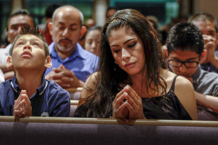 Xavier Albarran, 9, and his mother, Erika Albarran, pray during the Litany of Saints at a Mass celebrated July 27 by Bishop David R. Choby of Nashville, Tenn. (CNS photo/ Rick Musacchio, Tennessee Register)