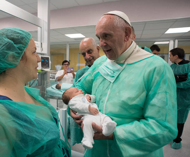 House of Mercy. Pope Francis holds a baby as he visits the neonatal unit at San Giovanni Hospital in Rome Sept. 16. The visit was part of the pope's series of Friday works of mercy during the Holy Year. (CNS photo/L'Osservatore Romano, handout)