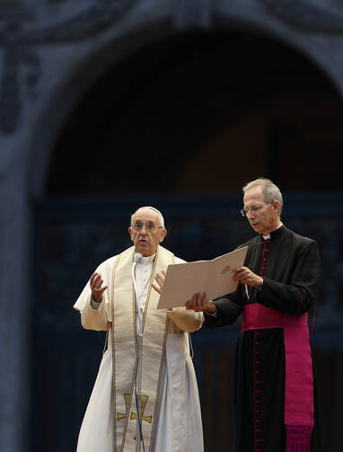 Pope Francis prays during a Marian vigil in St. Peter's Square at the Vatican Oct. 8. Also pictured is Msgr. Guido Marini, papal master of ceremonies. (CNS photo/Paul Haring)