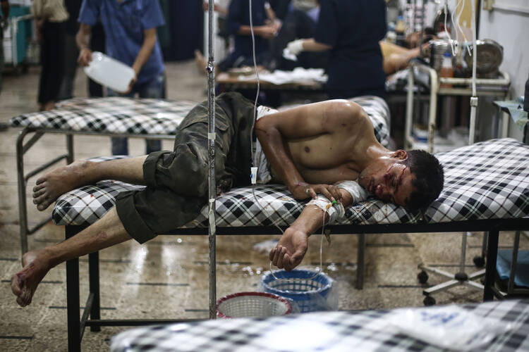 A young Syrian man receives medical treatment July 21 at a field hospital in the region of Douma in Damascus, Syria. (CNS photo/Mohammed Badra, Reuters)