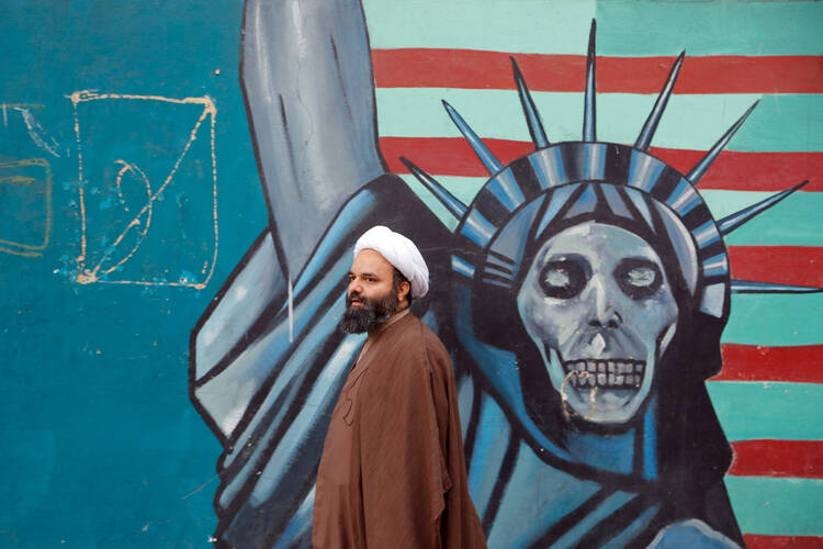 Getting Past Impressions. An Iranian cleric walks next to an anti-U.S. mural in Tehran Nov. 3. (CNS photo/Abedin Taherkenareh, EPA)