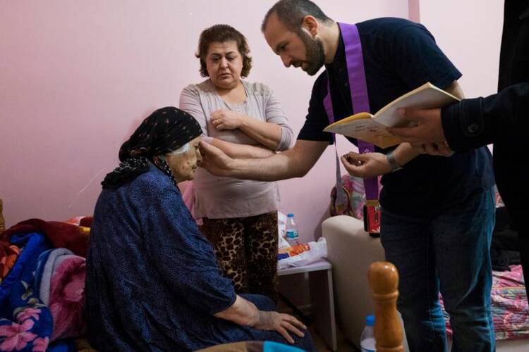 Chaldean Father Remzi Diril, also known as Father Adday, anoints Marta Kiryakos, a woman from Bartella, Iraq, who suffers from cancer, in this Nov. 10 photo. (CNS photo/Oscar Durand) 