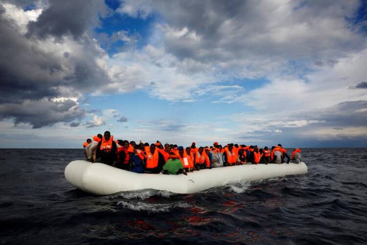 A raft with 112 passengers drifts in the Mediterranean Sea some 36 nautical miles off the Libyan coast on Jan. 2 before being rescued by members of a Spanish nongovernmental organization. (CNS photo/Yannis Behrakis, Reuters)