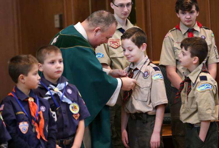 Father Sean Gann presents Children of God and Light of Christ medals to Scout honorees during a Mass marking Scout Sunday at St. Joseph Church in Kings Park, N.Y., on Feb. 5. (CNS photo/Gregory A. Shemitz)