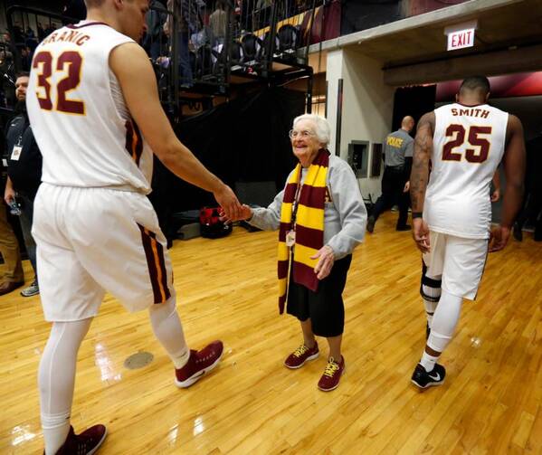 Longtime chaplain of the Loyola University Chicago men's basketball team and campus icon, Sister Jean Dolores Schmidt, 97, greets players after a game on Feb. 12. She is the newest member of the school's sports hall of fame. (CNS photo/Karen Callaway, Chicago Catholic)