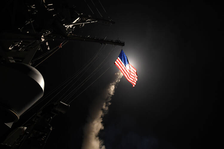 The USS Porter, in the Mediterranean Sea, fires a Tomahawk missile April 7. The U.S. Defense Department said it was a part of missile strike against Syria. (CNS photo/Ford Williams, U.S. Navy handout via Reuters)
