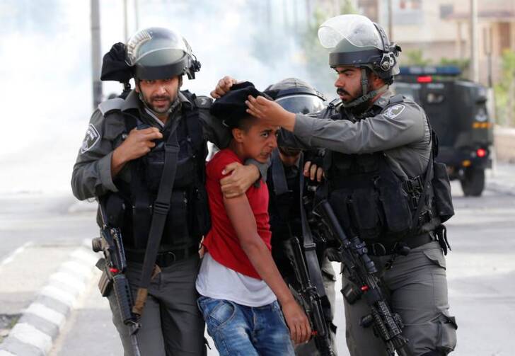 Israeli border policemen in Bethlehem, West Bank, detain a Palestinian protester in support of Palistinians in Israeli jails on April 27.  (CNS photo/Ammar Awad, Reuters)
