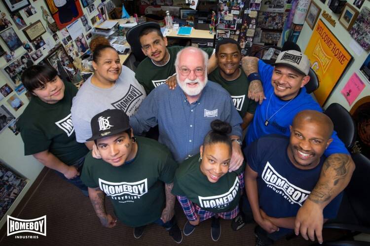 Jesuit Father Greg Boyle, founder of Homeboy Industries, poses for a photo with trainees in this undated photo