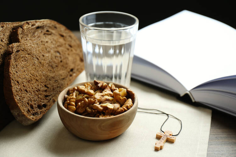 simple food and water in front of a book showing lenten fasting