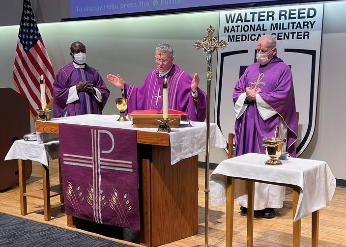 archbishop broglio celebrates mass wearing purple on ash wednesday with two other priests next to him, they are at the altar