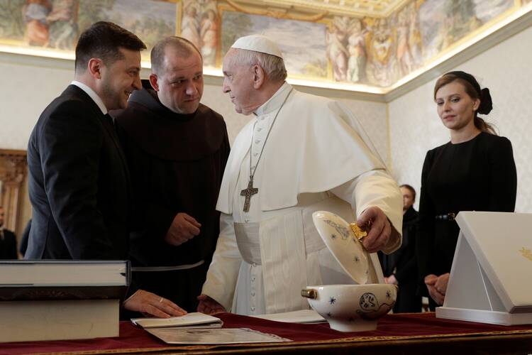 The pope greets several Ukrainian men in suits