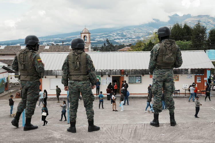 Soldiers guard a polling station during the presidential election in Ayora, Ecuador, Sunday, Aug. 20, 2023. The election was called after President Guillermo Lasso dissolved the National Assembly by decree in May to avoid being impeached. (AP Photo/Dolores Ochoa)