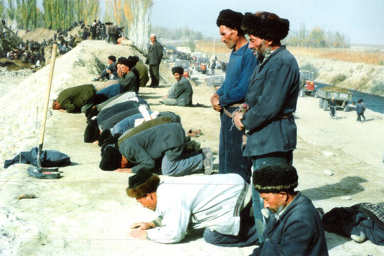 A group of Muslim Uyghurs pray during a work break in Xinjiang Province, China. (iStock/Gujiang Xie)