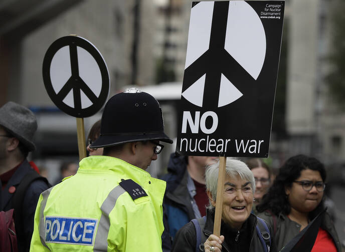 Anti war demonstrators hold banners as they protest outside Westminster Abbey, as a service to recognize 50 years of continuous deterrent at sea takes place in London on May 3. (AP Photo/Kirsty Wigglesworth)