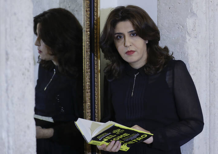 PR agent Francesca Chaouqui holds her book 'In the Name of Peter' (Nel Nome di Pietro), a behind-the-scenes drama of a papal reform commission, on Monday, Feb. 6, 2017. (AP Photo/Andrew Medichini)