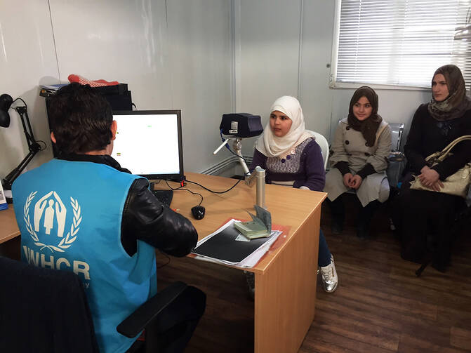 In this photo taken Sunday, Feb. 26, an 11-year-old Syrian refugee girl poses for a biometric iris scan in an interview room of the U.N. refugee agency in Amman, the first step in what are typically two years of interviews and background checks ahead of possible resettlement to the West, including the United States. (AP Photo/Karin Laub)