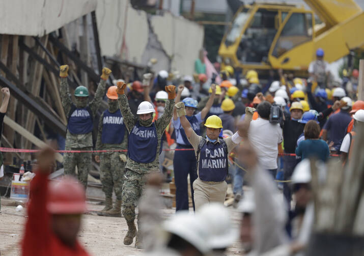 Soldiers hold up closed fists motioning for silence during rescue efforts at the Enrique Rebsamen school in Mexico City, Mexico, on Sept. 21. (AP Photo/Rebecca Blackwell)