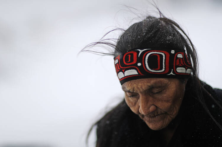 Grandma Redfeather of the Sioux Native American tribe walks in the snow to get water at the Oceti Sakowin camp in November, where people protesters gathered the Dakota Access oil pipeline in Cannon Ball, N.D. (AP Photo/David Goldman, File).