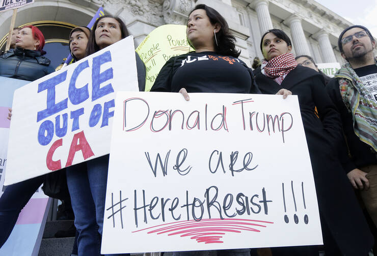 Protesters hold signs as they listen to speakers at a rally outside of City Hall in San Francisco, Wednesday, Jan. 25, 2017. President Donald Trump moved aggressively to tighten the nation's immigration controls Wednesday, signing executive actions to jumpstart construction of his promised U.S.-Mexico border wall and cut federal grants for immigrant-protecting "sanctuary cities." (AP Photo/Jeff Chiu)