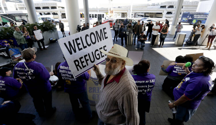 Demonstrators outside Tom Bradley International Terminal during a protest by airport service workers from United Service Workers West union on Jan. 30, 2017, at Los Angeles International Airport. The vigil is in support of travelers affected by the executive order restricting travel from seven primarily Muslim countries. (AP Photo/Chris Carlson)