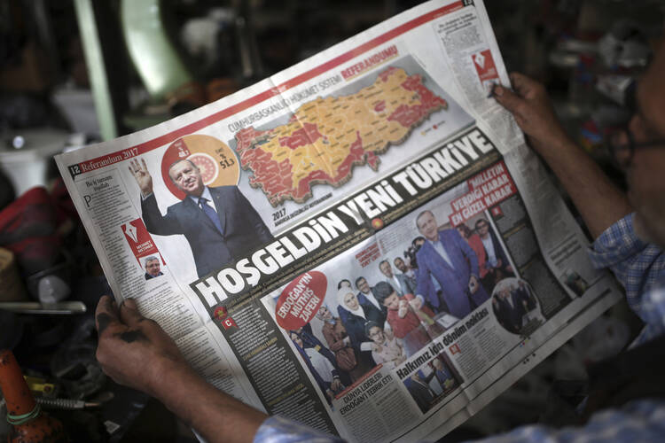 A man reads a newspaper with images of Turkey's President Recep Tayyip Erdogan and a map showing the results of Sunday referendum, in Diyarbakir, Turkey, on Monday, April 17, 2017. (AP Photo/Emre Tazegul)