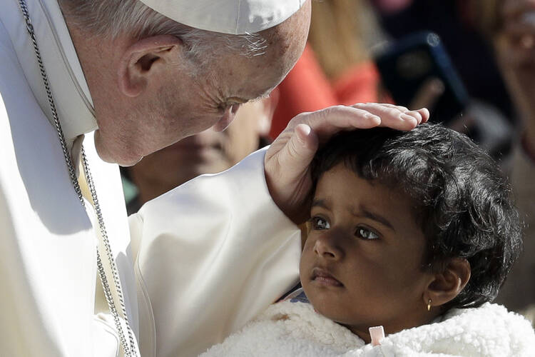 Pope Francis caresses a child as he arrives for his weekly general audience, at the Vatican, Wednesday, on March 29, 2017. (AP Photo/Andrew Medichini)
