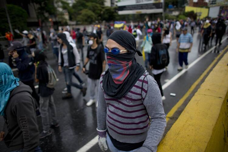 Demonstrators march on a highway as Bolivarian National Guard soldiers block their way during an anti-government protest in Caracas, Venezuela, Thursday, April 13, 2017. Venezuela officials are confirming that a fifth person has died in a two-week old anti-government protest movement. (AP Photo/Ariana Cubillos)