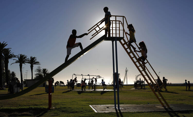 Children climb a slide in the public play area in Three Anchor Bay in Cape Town, South Africa, Dec. 29, 2014. 