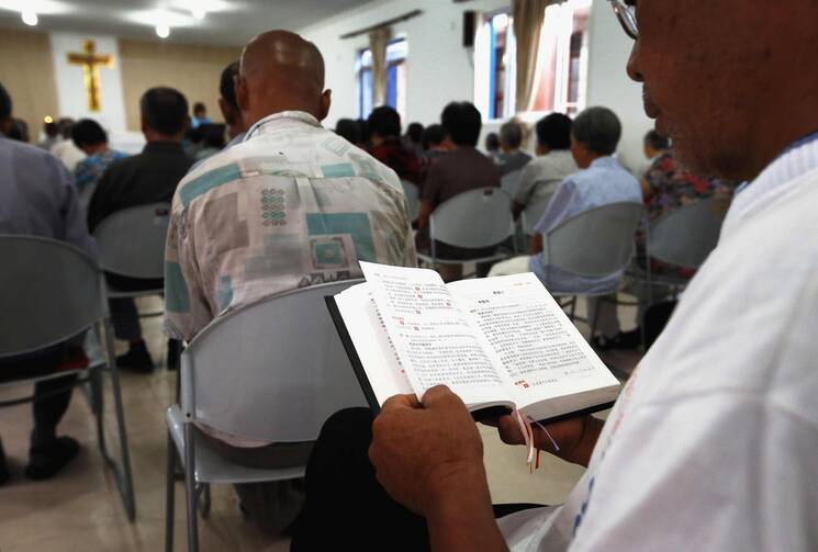 A man reads from a missal during Mass in a makeshift Catholic chapel in a village outside Tianjin, China, July 2012.