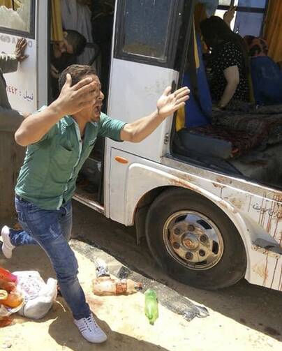 A man screams beside a bus carrying Coptic Christians which came under attack outside Cairo, Friday, Nov. 2, 2018. Islamic militants on Friday ambushed a bus carrying Christian pilgrims on their way to a remote desert monastery south of the Egyptian capital, killing at least seven and wounding a dozen more, the Interior Ministry said.(Egypt’s Coptic Orthodox Church via AP)