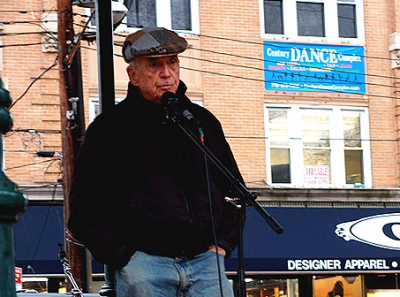 A Familiar Pose. Father Berrigan speaks in October 2006 at the 3rd Annual Staten Island Freedom & Peace Festival. Photo by Clara Sherley-Appel; Wikicommons