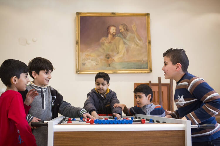 Boys plays foosball March 25 at Don Bosco youth center in Istanbul. (CNS photo/Elie Gardner)
