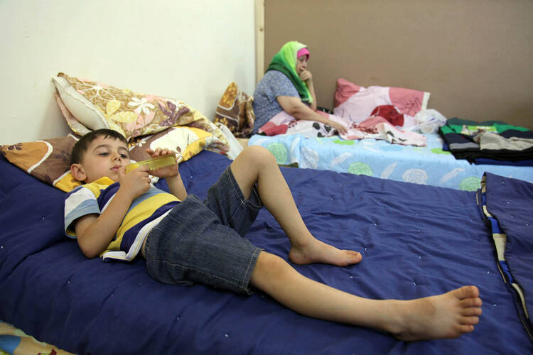 Iraqi Christian children who fled from religious-based violence in Mosul, Iraq, lie on a bed Aug. 21 at Mar Elias Monastery Church in Amman, Jordan. (CNS photo/Jamal Nasrallah, EPA)